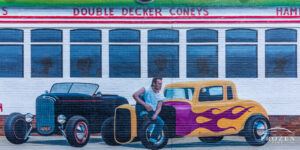 A mural depicting a 1950s diner with period roadsters in front