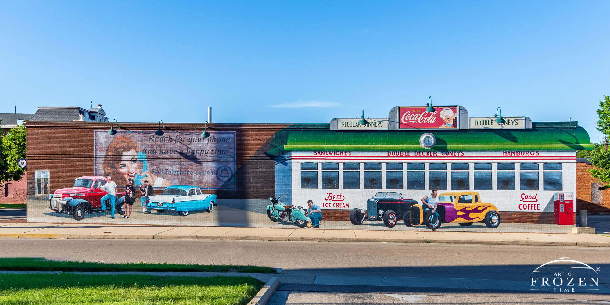 A panorama of an Eric Henn Mural showing 1950s life in front of a classic diner complete with roadsters, motorcycles and young adults in conversation
