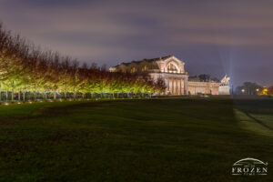 A nightscape image of the walkway to the St Louis Art Museum where the curve walkway lights up light the maple trees as well as the St Louis icon sculpture, the Apotheosis of St. Louis