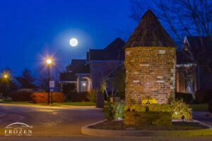 A brick monument in O’Fallon Illinois at the Thornbury Hill entrance as the full moon rises into the evening sky