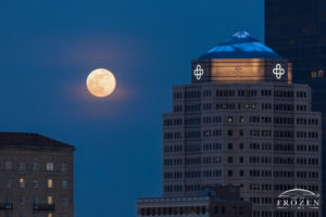 A full moon rising over the Dayton Skyline next to the Premier Health Corporate Headquarters