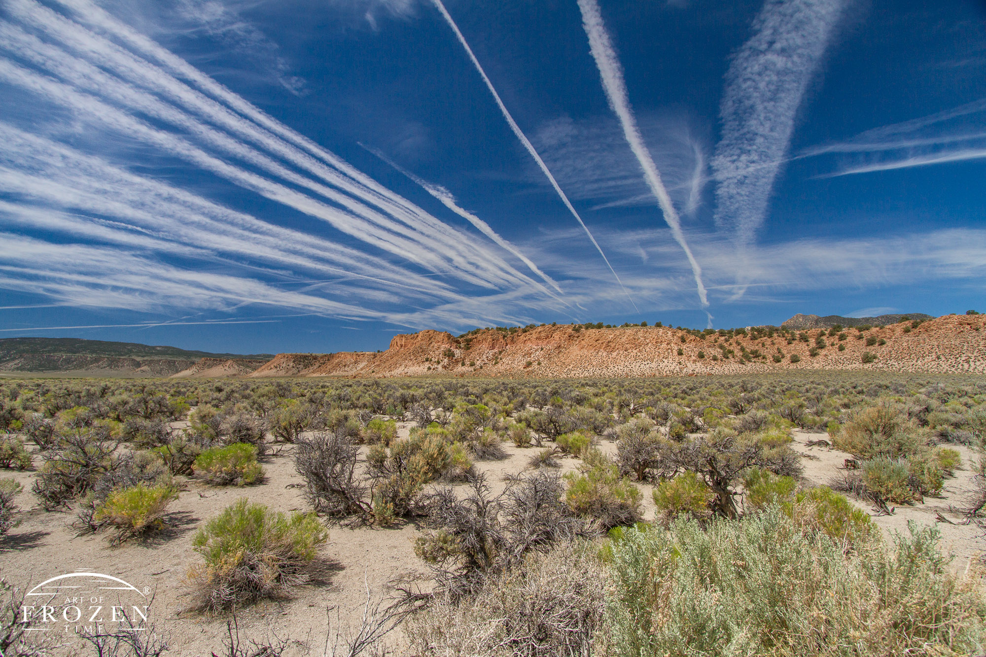 A series of contrails over eastern California which stretch across the blue sky in successive rows