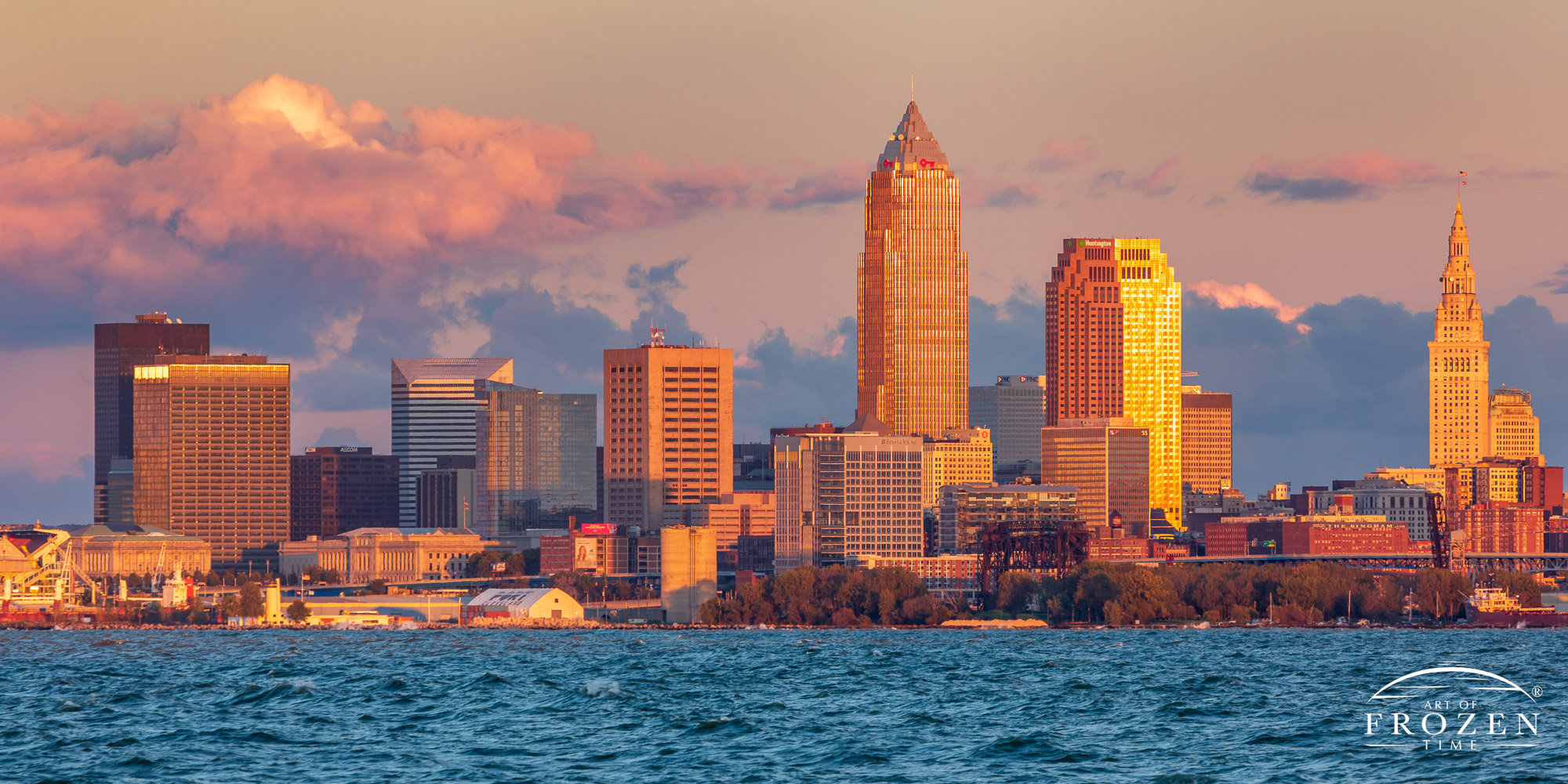 Strong winds over Lake Erie rush ashore over Cleveland, Ohio, as the setting sun paints the skyline in warm light