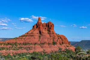 An Arizona red rock formation with a broad concentric base and narrow pinnacle that resembles a church bell which extends 500 feet into the blue sky over Sedona