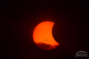 A close up view of a solar eclipse and prominent sunspots where the moon partially obscures the sun