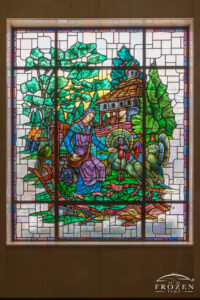 Stained-glass window in Woodland Mausoleum showing Evangeline feeding turkeys near a plow with barns and beehives in the background in Dayton Ohio