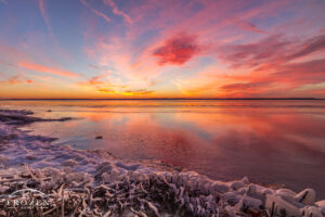 A colorful winter sunset at Rend Lake where the ice covered shoreline creates foreground interest as the sky ignites with fiery colors