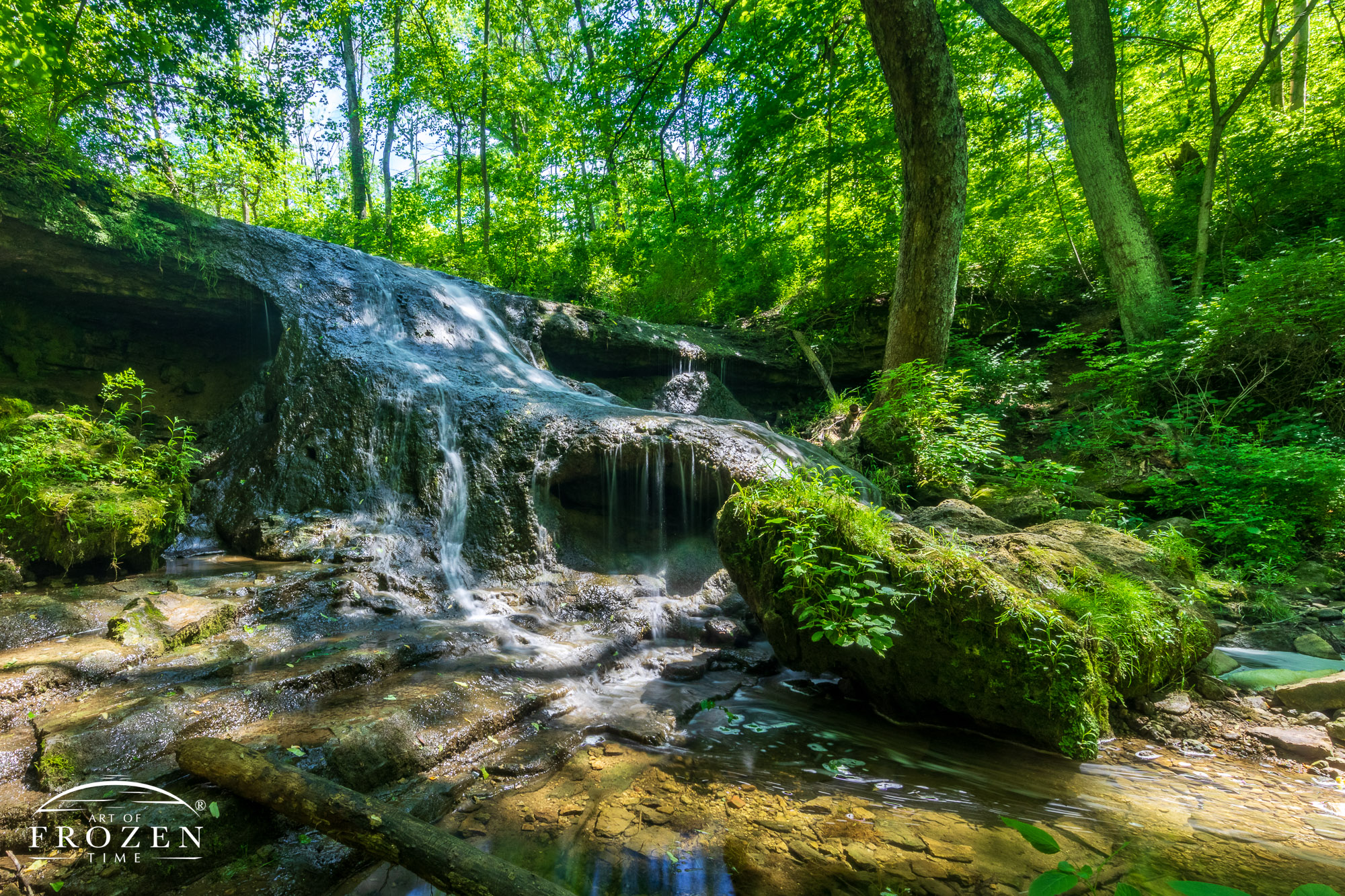 A forest waterfall where upstream sediments have created a gentle slope for the water to run down.