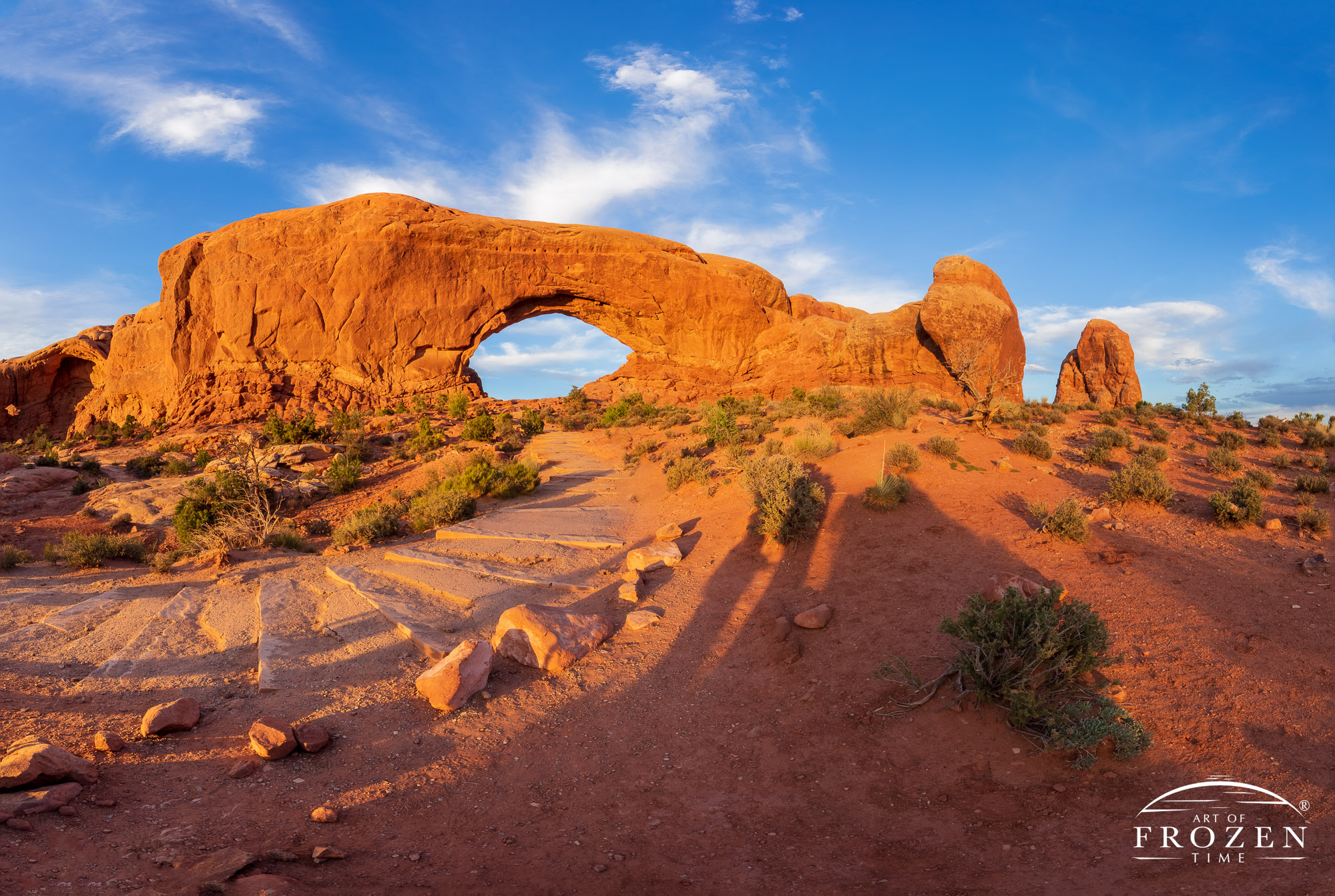 Sunset over Turret Arch and Double Arch, Arches National Park, where the low-angled sunlight rakes over the red sandstone