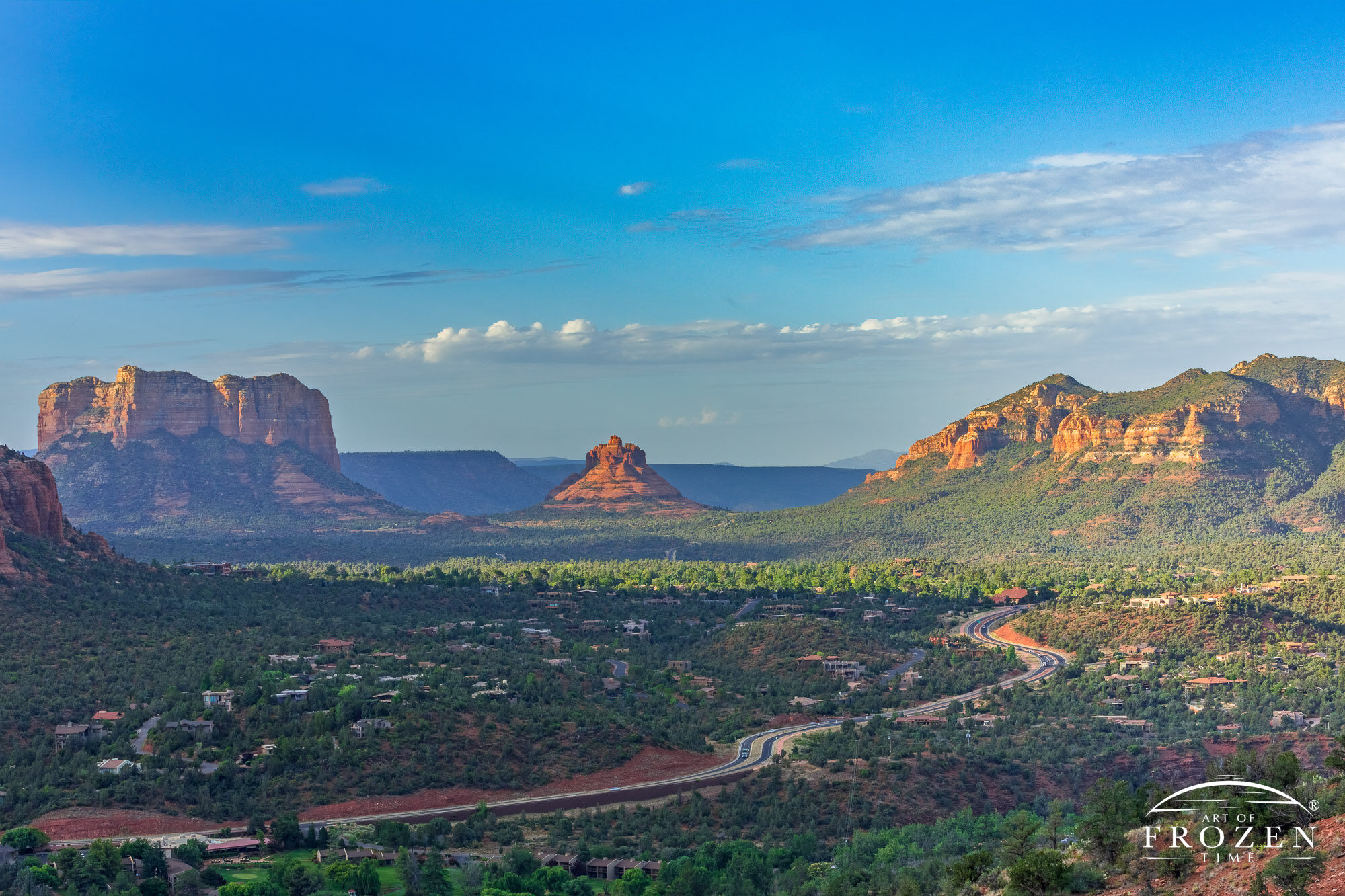 A morning view of Arizona State Route 179 leading the eye towards Sedona’s Bell Rock formation where golden light washes over the red rocks of the Schnebly Hill Formation