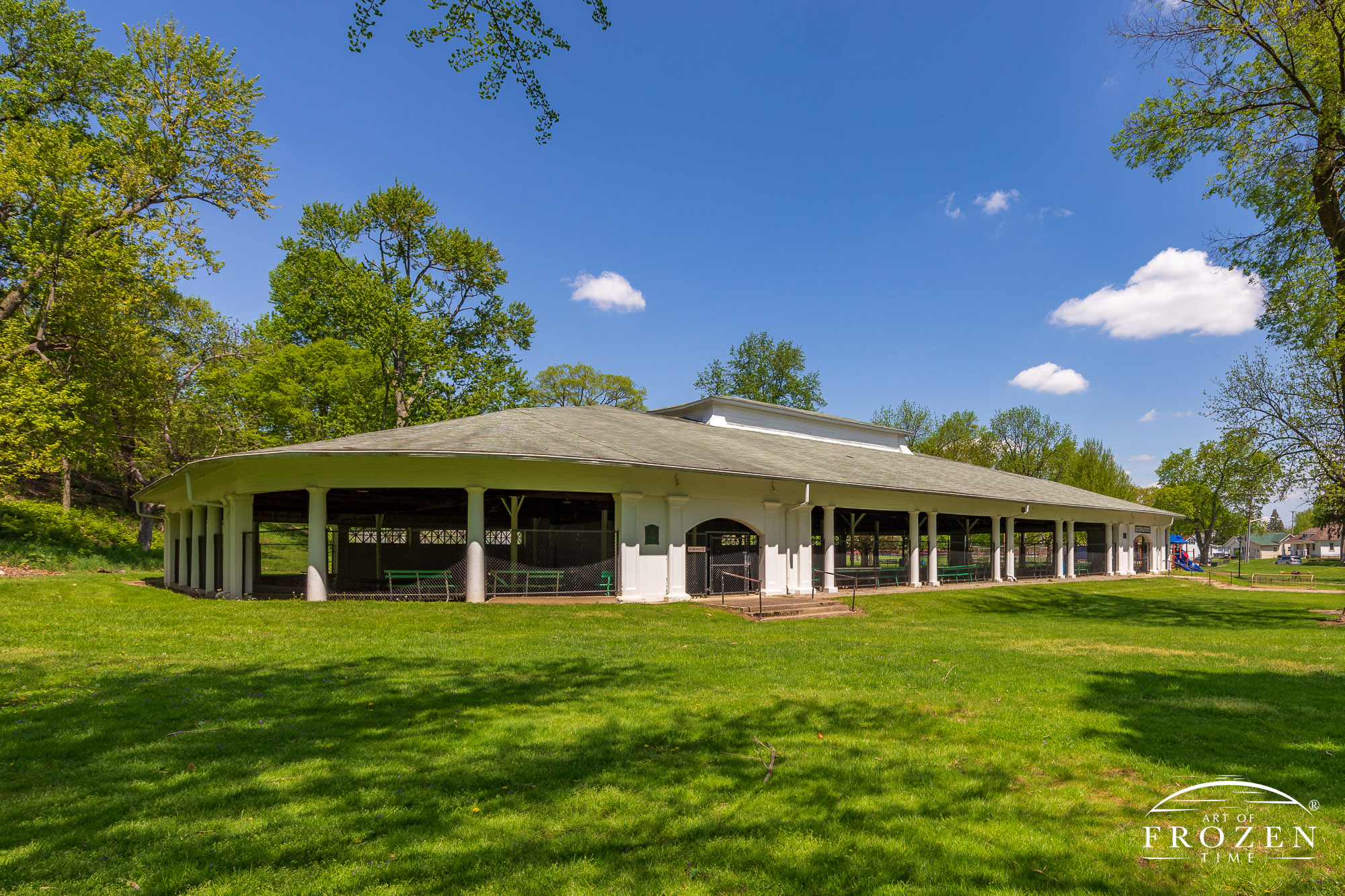 An open-air venue in Fountain Park offers guest plenty of shade trees on this spring day as a few puffy clouds pass through the blue sky