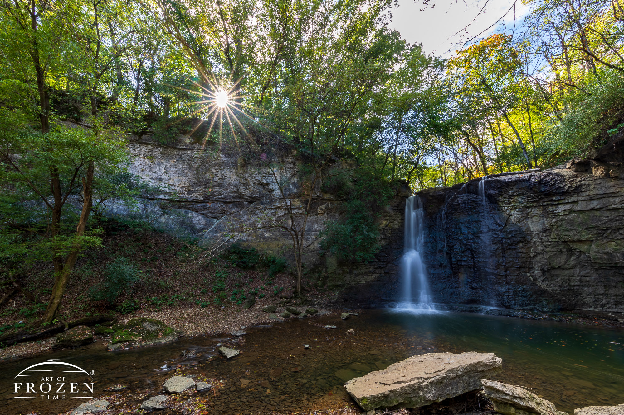 A panoramic view of Hayden Falls as the surrounding trees filter the evening sun