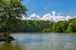 An Ohio lake scene at Hosterman Lake near Enon Ohio showing a tree-lined lake under blue skies