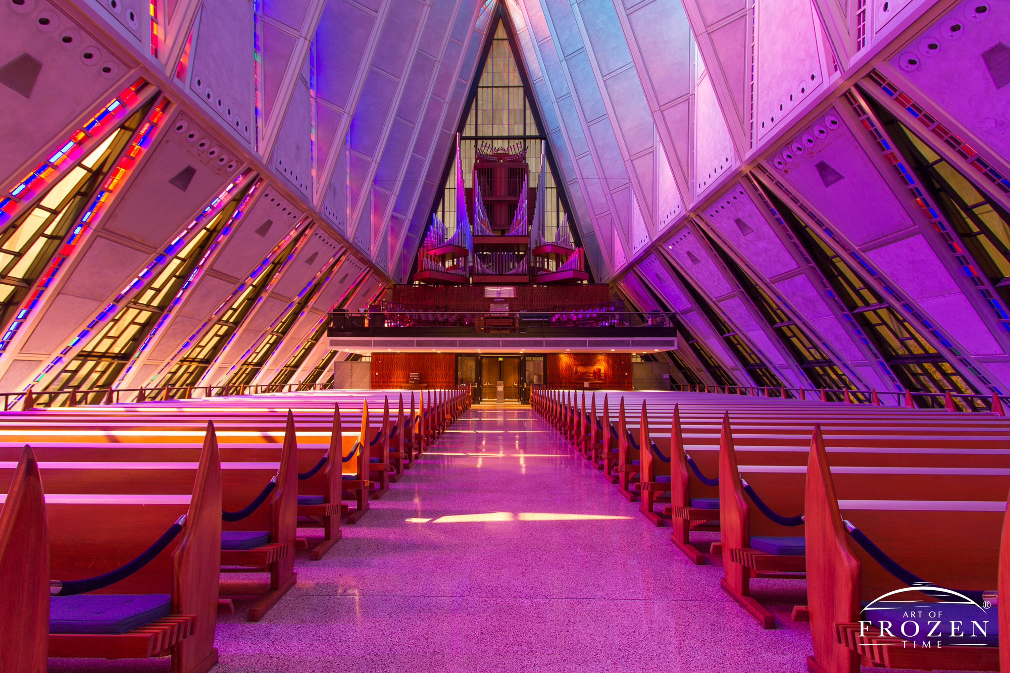 As sunrise occurs over the Air Force Academy Cadet Chapel, its pink and lavender stain glass windows fill the interior with unique hues