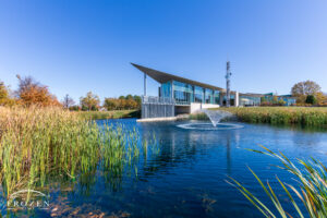An architecturally pleasing building whose angular construction juts out over a small pond