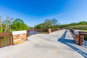 A wide pedestrian bridge spanning the Great Miami River on a spring day with really blue skies