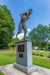 A park and monument to Jim Thorpe on a blue sky day where the sun shines on the city’s namesake