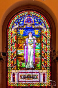 Stained-glass window featuring a blindfolded woman holding the scales of justice