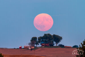 A few minutes after an October moonrise, where the large Hunters Moon hangs over a Lebanon Illinois farmhouse