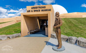 A bronze statue of Neil Armstrong dressed as a test pilot to include his flight helmet and oxygen mask