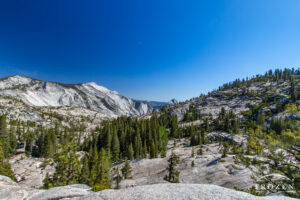 A vista from Olmsted Point in Yosemite that encompasses Clouds Rest and Half Dome under blue azure skies