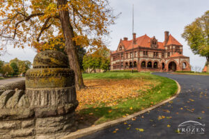 An outside view of a mansion in Springfield, Ohio, featuring Richardsonian Romanesque Architecture where autumn-colored trees match the home’s warm colors.