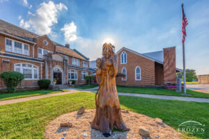 A sculptured dead tree now depicts Jesus as a shepherd as it stands outside Springfield’s Grace United Methodist Church during a summer evening.