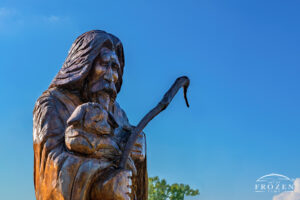 A sculptured dead tree now depicts Jesus as a shepherd as it stands outside Springfield’s Grace United Methodist Church during a summer evening.