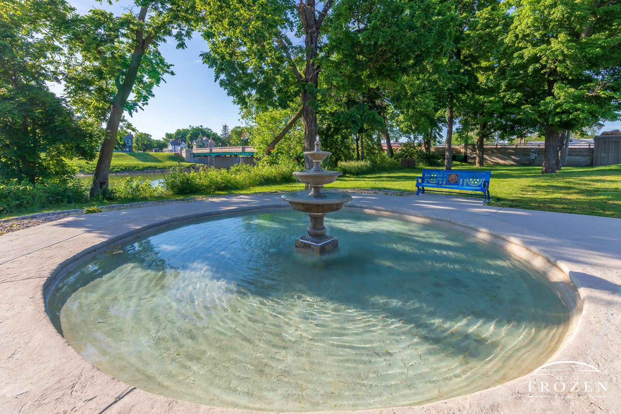 An English multi-tiered fountain standing along South River Street in Franklin, Ohio where visitors can admire the trickling water while sitting on shaded benches