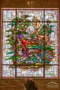 Stained-glass window of St. Hubert kneeling before a stag with a crucifix between its antlers inside Woodland Cemetery mausoleum in Dayton Ohio