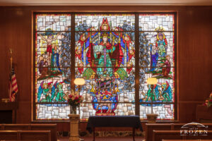 Historic stained-glass windows created by Louis Comfort Tiffany featuring his opalescent glass feuturing the Messiah sitting on a throne surrounded by angels and saints