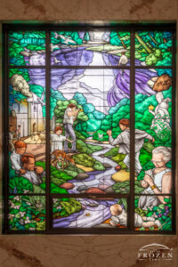 The River of Life Stained-glass Window, Woodland Cemetery and Arboretum | Art of Frozen Time A stained glass window depicting people and animals.