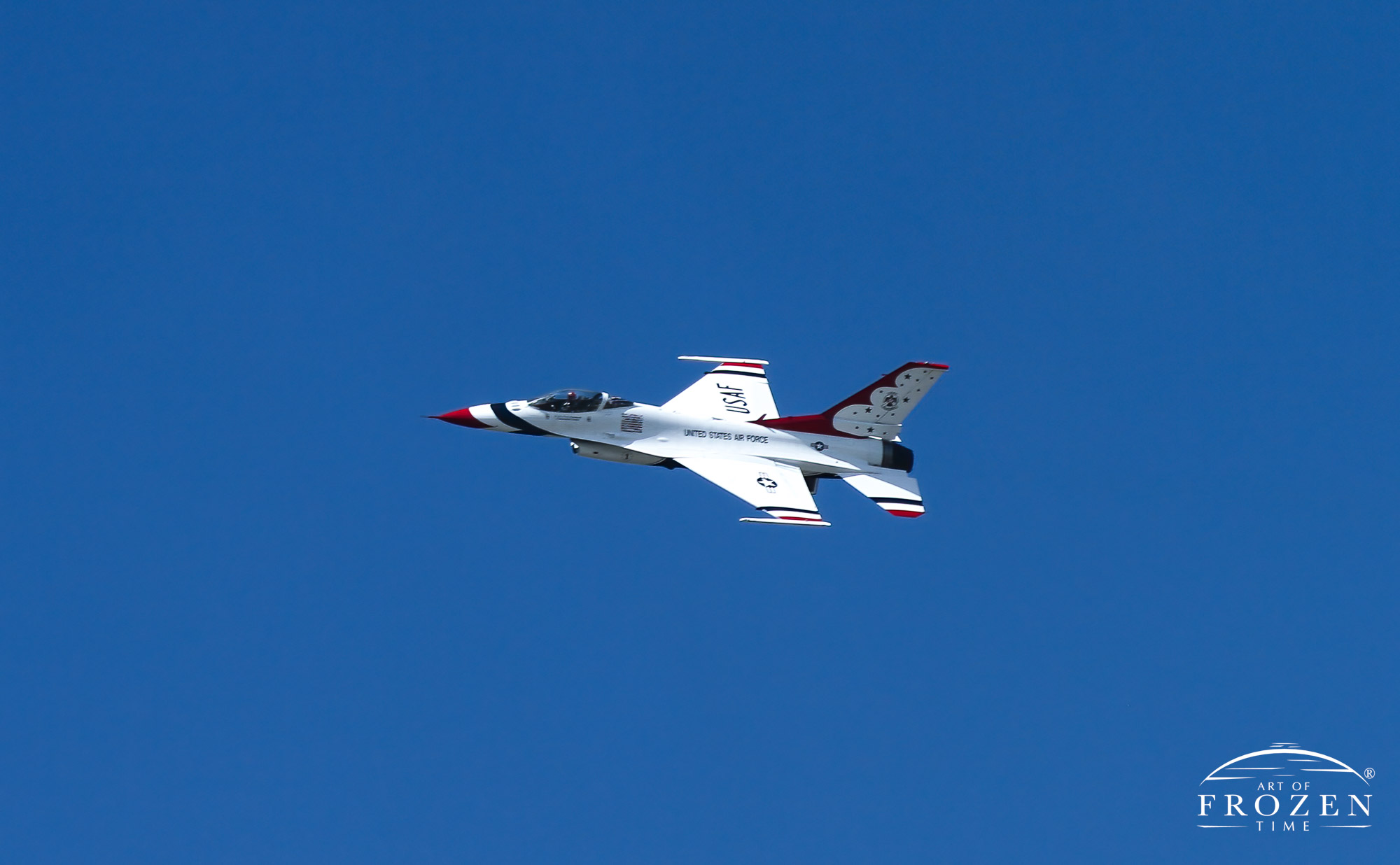 The bright white Air Force Thunderbird finish contrasts with burning blue sky during an airshow flyby