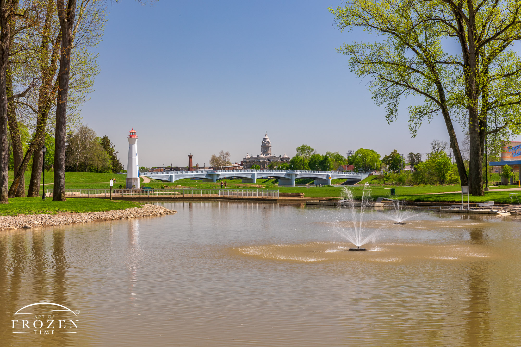 A view from Smith’s Boathouse Restaurant balcony showing the Great Miami River, Adams Street Bridge and the Miami County Courthouse all under blue skies