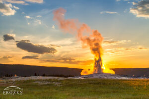 The backlit spray from Old Faithful in this sunset image forms a pareidolia where a Victorian dressed lade appear to rise from the geyser