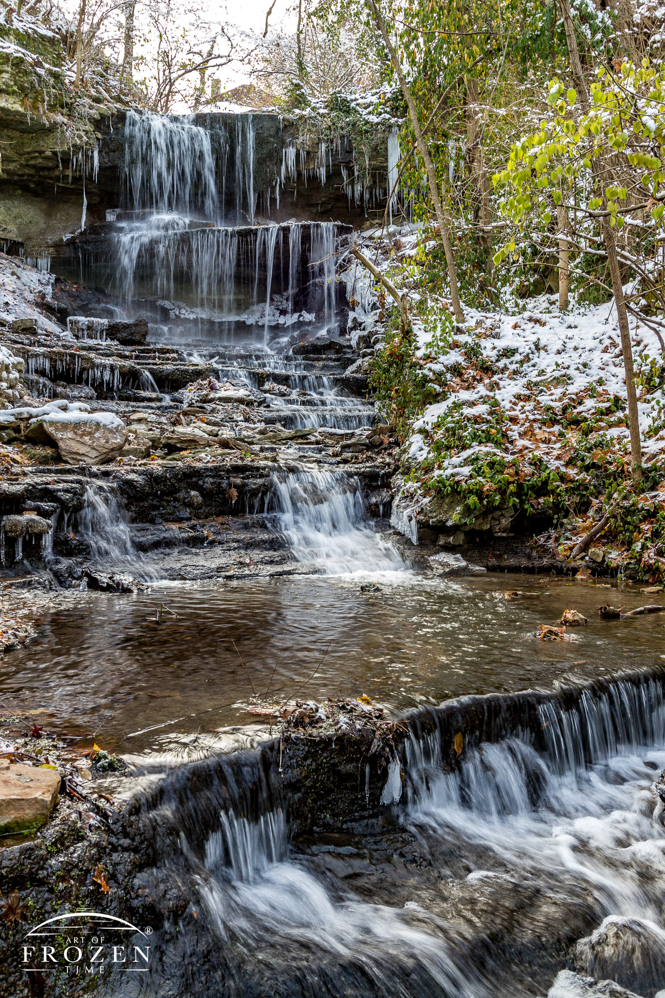 A winter waterfall in West Milton, Ohio where snow and icicles hang from rock outcrops