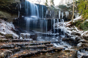 A waterfall in West Milton, Ohio where a long exposure turns the water into curtains of white as the water runs over the snow-covered ledges