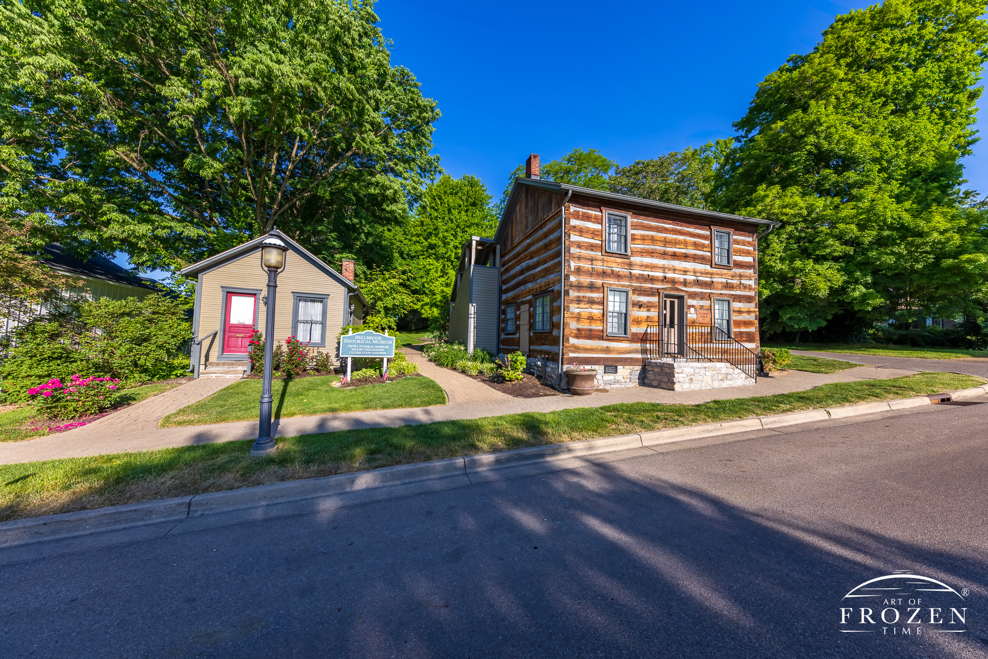A Greene County historical structure where a refurbished log home stands in Bellbrook, Ohio under blue skies.
