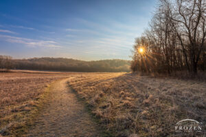 Golden light washes over a prairie trail following a frosty winter sunrise.