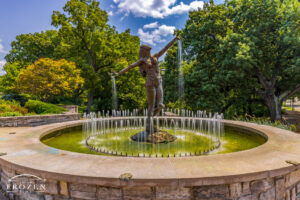 A graceful sculpture titled the Muse of Clifton stands in Burnet Woods on a summer day where water streams from her open palms.