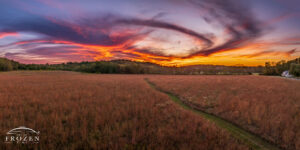 Aerial panorama of Morris Reserve prairie near Bellbrook Ohio at sunset with spiral cirrus clouds and colorful orange pink and purple twilight sky