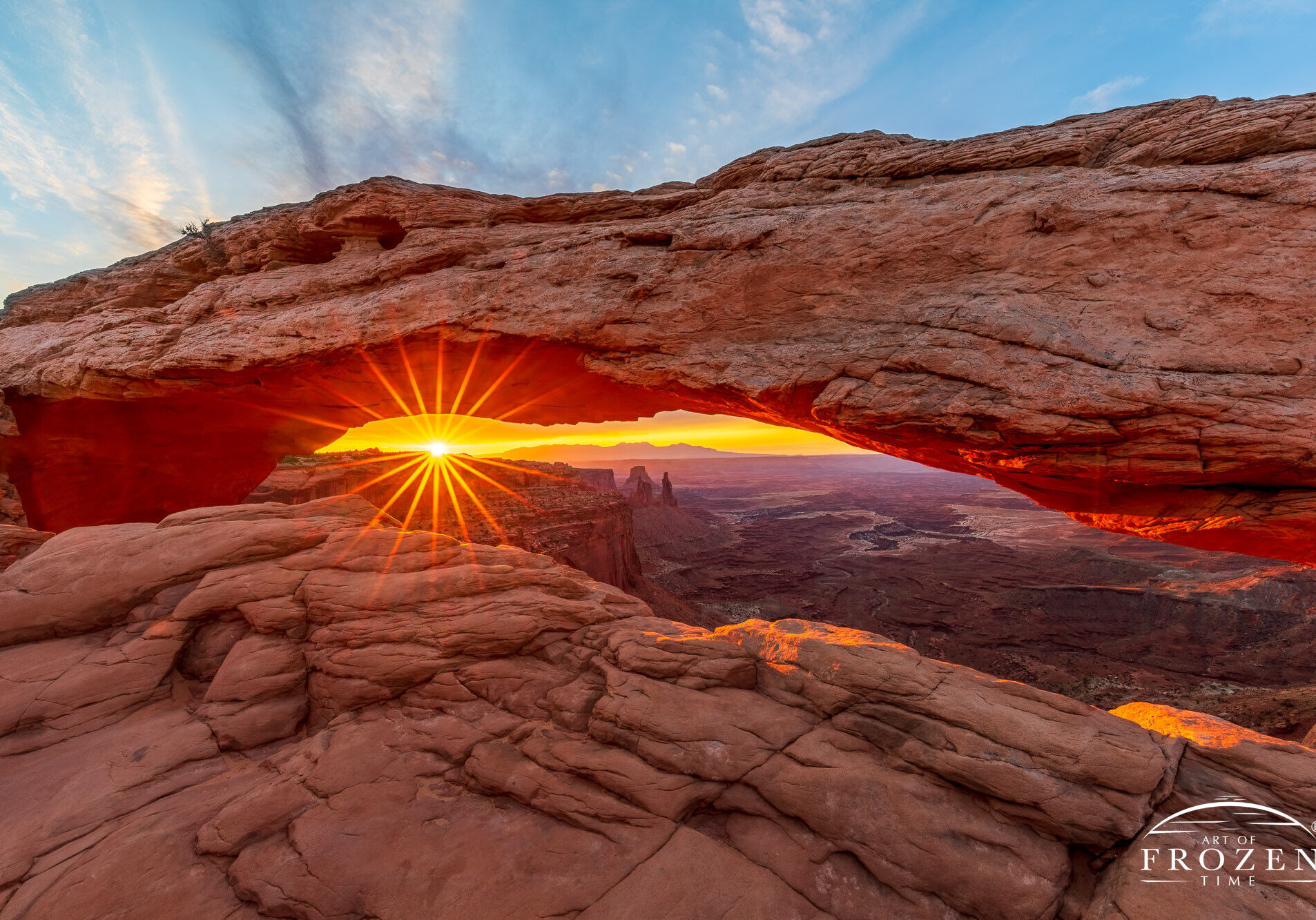 Mesa Arch Sunburst A burst of vivid sunlight through Mesa Arch, where light diffraction renders the morning sun as a stunning sunstar framed by the sandstone rock arch